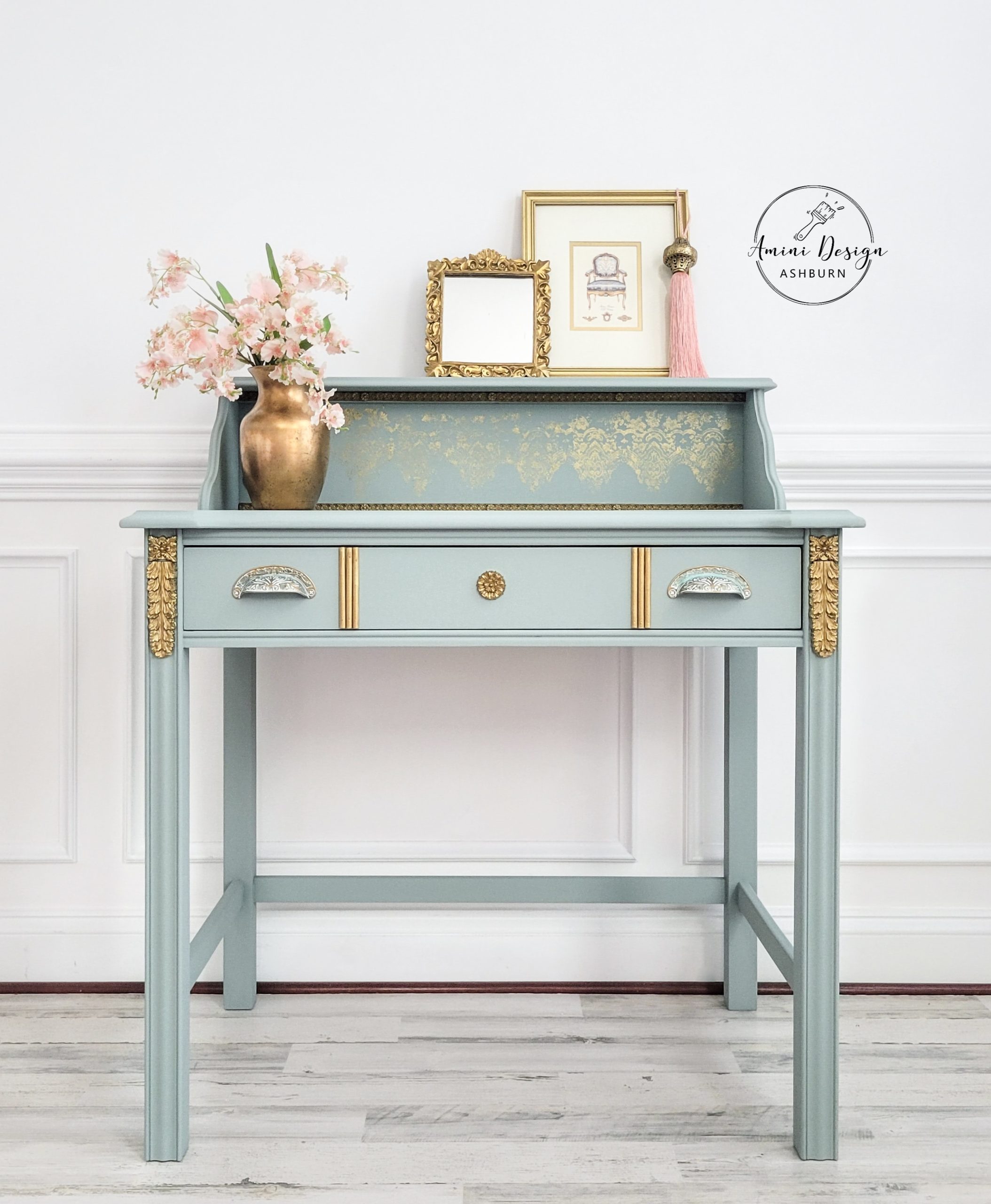 Ornate antique secretary desk painted in pastel green with gold decorative accents